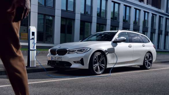 Plug-in HybridBMW Σειρά 3 Touring, 2021 G21, μπροστινή λήψη τριών τετάρτων σε φόρτιση Plug-in HybridBMW Σειρά 3 Touring, 2021 G21, μπροστινή λήψη τριών τετάρτων μπροστά από κτίριο