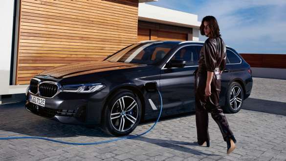 Plug-in υβριδική BMW Σειρά 5 Touring, 2021, G31, LCI, πλαϊνή λήψη τριών τετάρτων, σε φόρτιση Plug-in υβριδική BMW Σειρά 5 Touring, 2021, G31, LCI, πλαϊνή λήψη τριών τετάρτων, σε φόρτιση, με μοντέλο