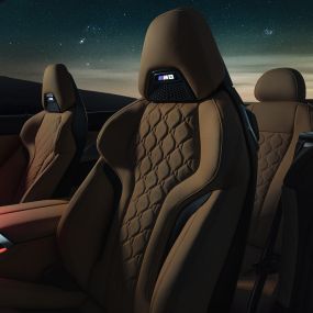 Σπορ καθίσματα M σε δέρμα 'Merino'. BMW M8 Competition Cabrio με ανοικτή υφασμάτινη οροφή κάτω από έναστρο ουρανό, εσωτερικό με σπορ καθίσματα M σε δέρμα 'Merino' και κόκκινο ατμοσφαιρικό φωτισμό.