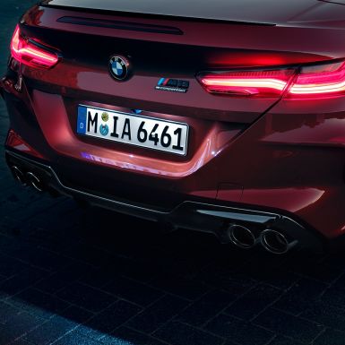 BMW M8 Competition Cabrio, κοντινή πίσω λήψη. BMW M8 Competition Cabrio σε κόκκινο Motegi μεταλλικό, κοντινή λήψη στο πίσω τμήμα με πίσω φώτα LED και σήμα M8 Competition.