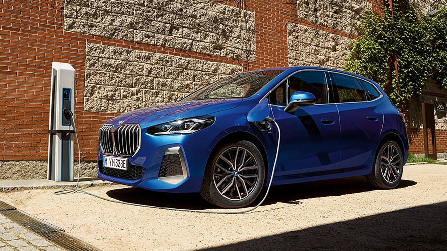 BMW Σειρά 2 Active Tourer 230e, plug-in υβριδική, U06, 2021, σε σταθμό φόρτισης BMW Σειρά 2 Active Tourer 230e, plug-in υβριδική, U06, 2021, M μπλε Portimao μεταλλικό, πλαϊνή λήψη τριών τετάρτων σε σταθμό φόρτισης