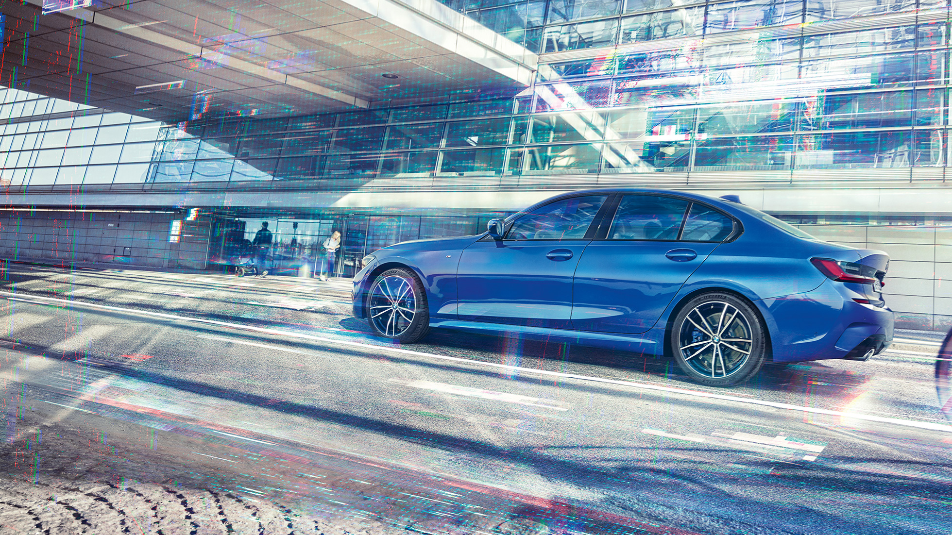 BMW Σειρά 3 Sedan, πλαϊνή όψη. Στατική λήψη της BMW Σειράς 3 Sedan από το πλάι, την ημέρα, μπροστά από ένα γυάλινο κτίριο.