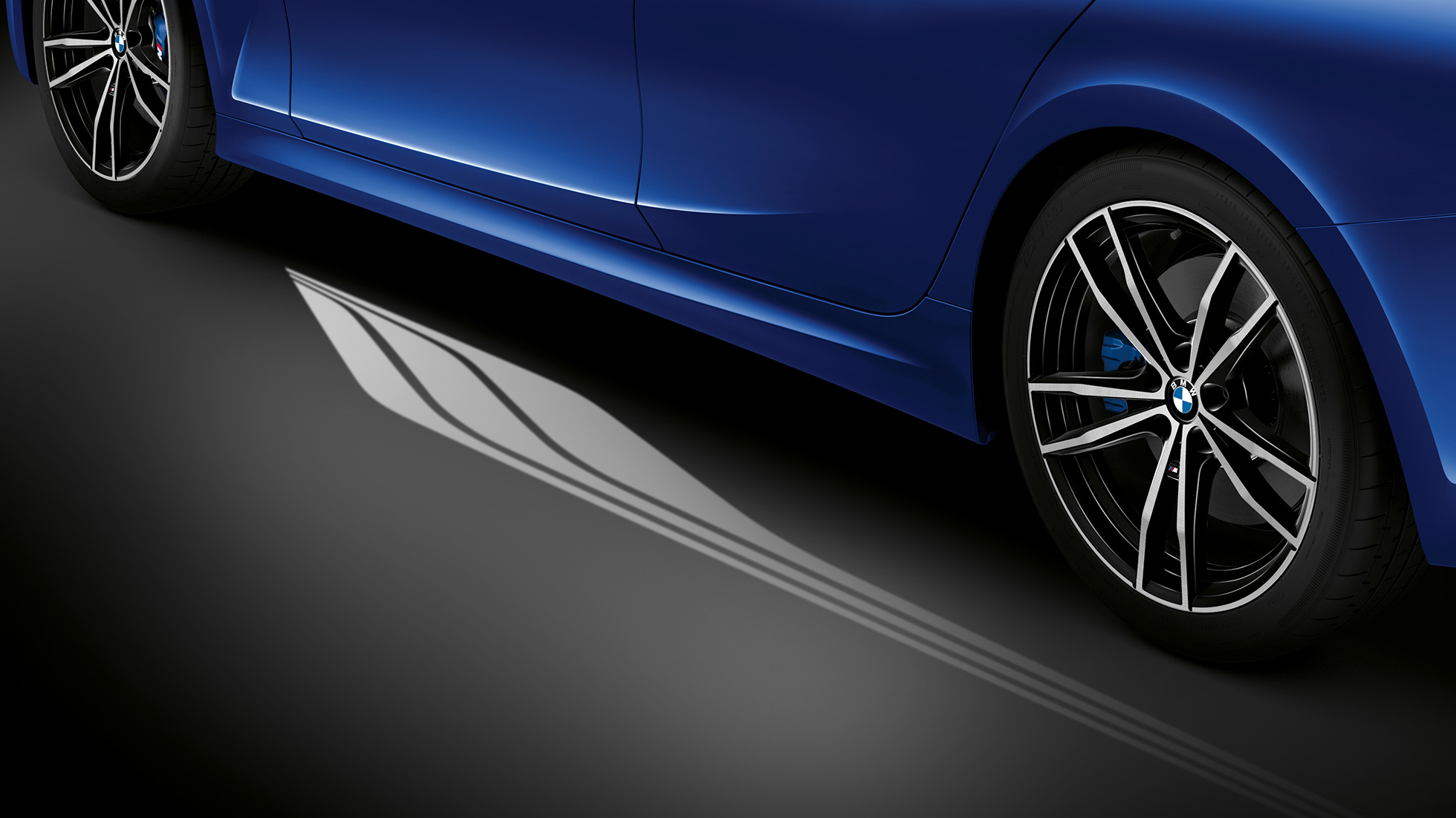 BMW Σειρά 3 Sedan, Welcome Light Carpet. Μπροστινή όψη της θέσης οδηγού στην BMW Σειρά 3 Sedan με μπλε ατμοσφαιρικό φωτισμό στον φωτιζόμενο χώρο ποδιών.