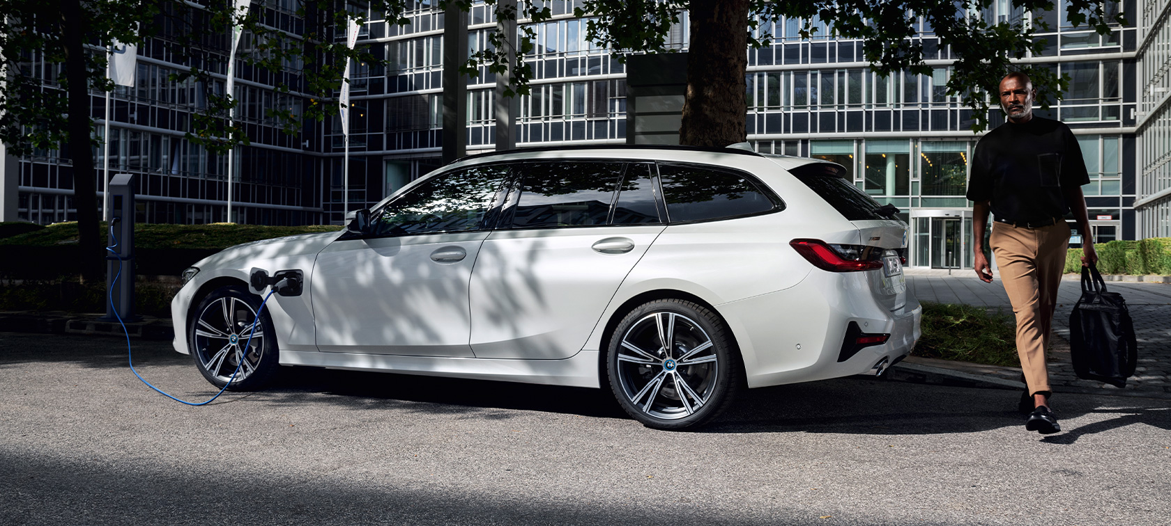 Plug-in υβριδική BMW Σειρά 3 Touring, 2021 G21, πλαϊνή λήψη τριών τετάρτων, σε φόρτιση Plug-in υβριδική BMW Σειρά 3 Touring, 2021 G21, πλαϊνή λήψη τριών τετάρτων, σε φόρτιση με μοντέλο