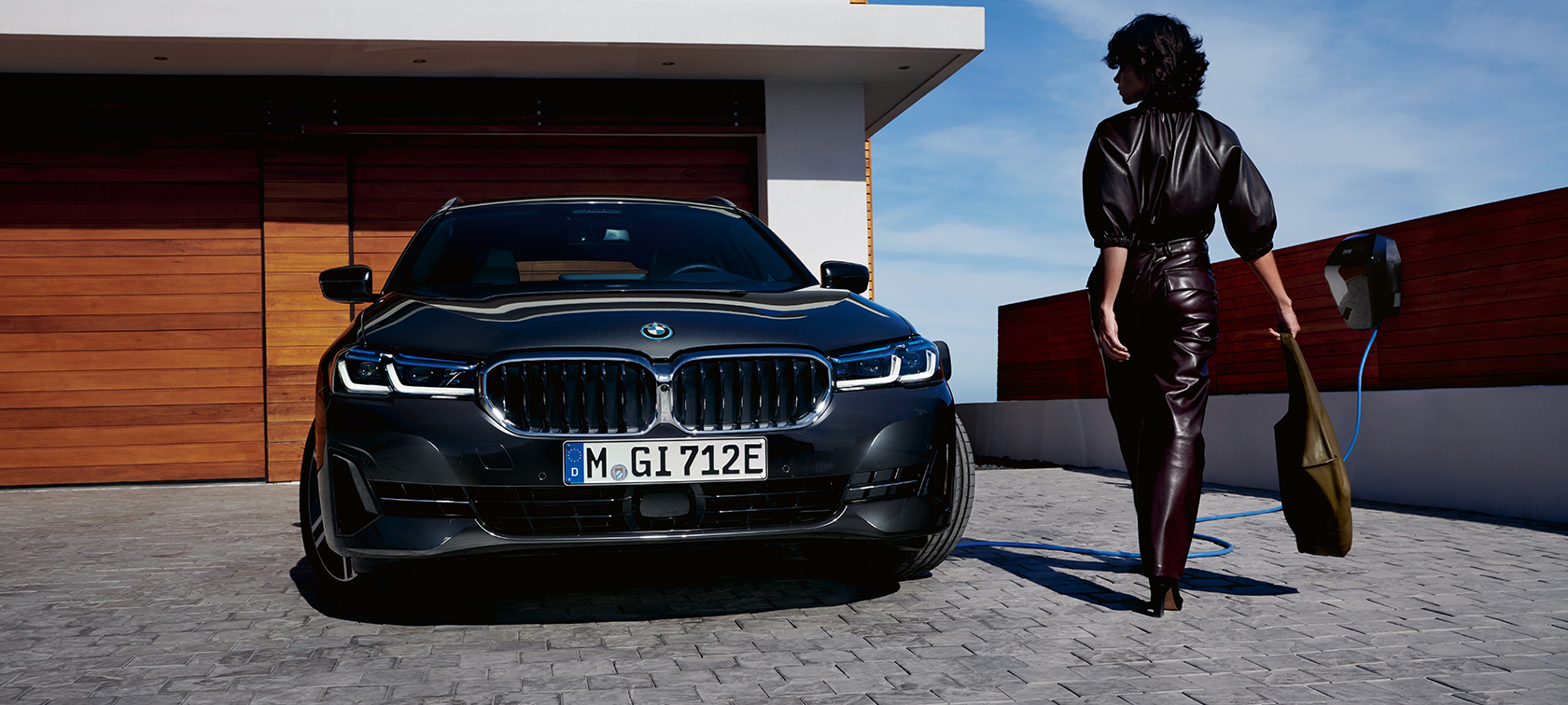 Plug-in υβριδική BMW Σειρά 5 Touring, 2021, G31, LCI, μπροστινή λήψη, σε φόρτιση Plug-in υβριδική BMW Σειρά 5 Touring, 2021, G31, LCI, μπροστινή λήψη, σε φόρτιση, με μοντέλο
