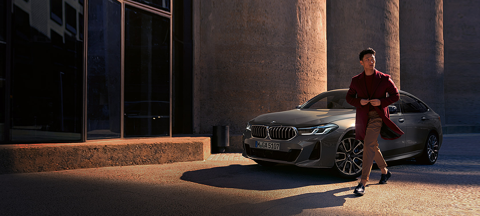 BMW Σειρά 6 Gran Turismo 640i xDrive, G32, 2020, γκρι Bernina, άντρας μπροστά από την BMW, μπροστινή λήψη τριών τετάρτων, σταθμευμένη