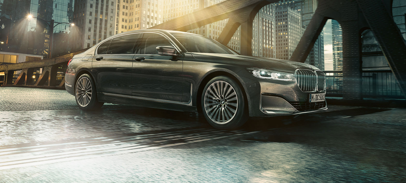 BMW Σειρά 7 Sedan, πλαϊνή όψη BMW Σειρά 7 Sedan σε πλαϊνή όψη με ανοικτή πόρτα μπροστά από φωτισμένο ξενοδοχείο
