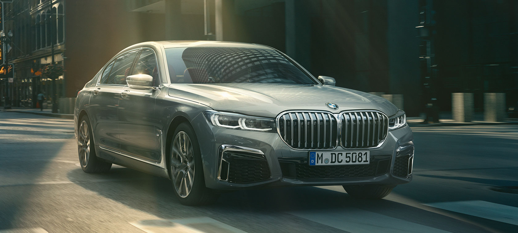 Γκρι BMW Σειρά 7 Sedan σε κίνηση, μπροστινή όψη τριών τετάρτων Γκρι BMW Σειρά 7 Sedan κινείται σε αστικό σκηνικό, μπροστινή λήψη τριών τετάρτων