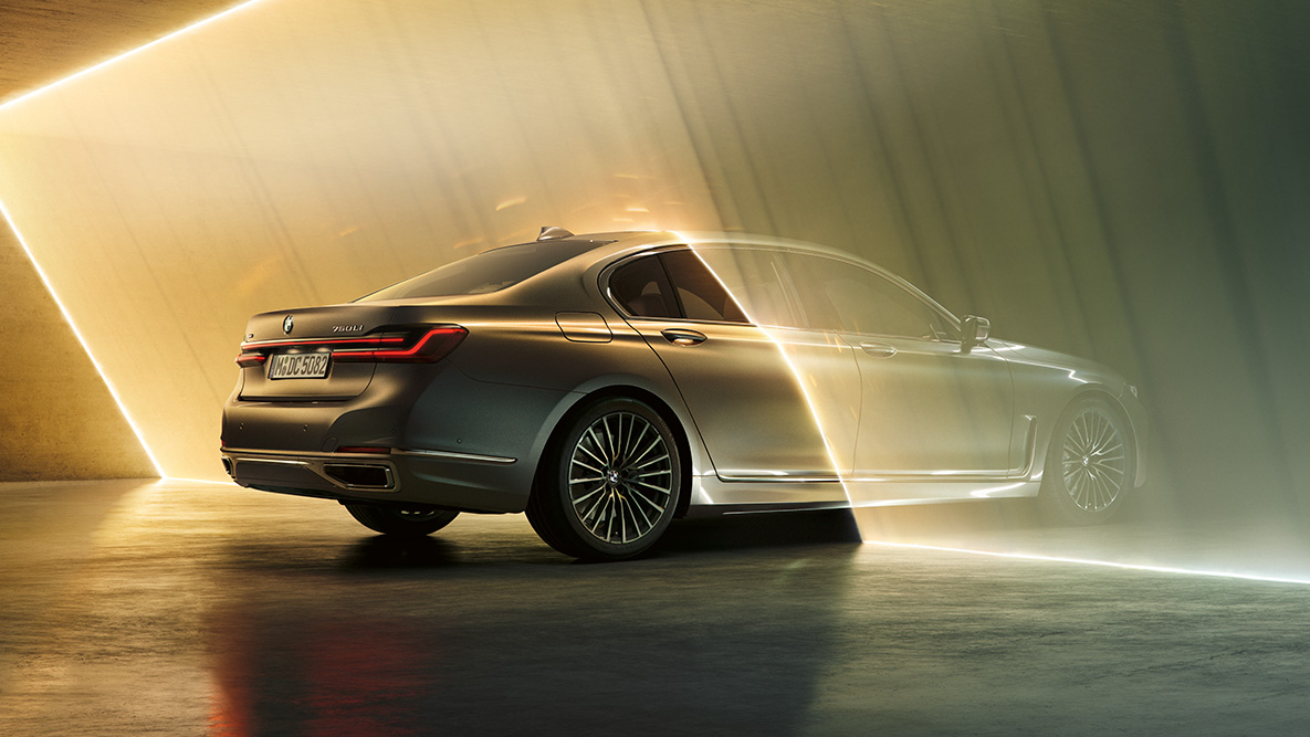 BMW Σειρά 7 Sedan σε γκρι Bernina BMW Σειρά 7 Sedan σε γκρι Bernina, μπροστινή όψη τριών τετάρτων, πλαισιωμένη από φωτεινές ακτίνες