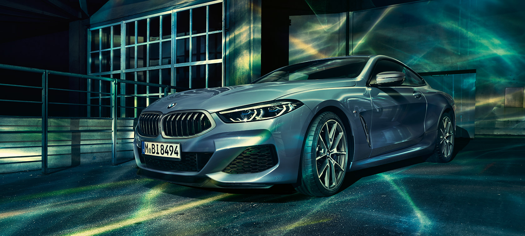 Η BMW Σειρά 8 Coupé, μπροστινή λήψη τριών τετάρτων. Η BMW Σειρά 8 Coupé, μπροστινή λήψη τριών τετάρτων, μπροστά από κτίριο βιομηχανίας.