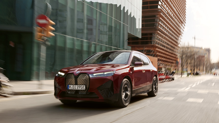 BMW iX i20, ηλεκτρικό SUV, BMW iX, xDrive50, υποστήριξη οδηγού BMW iX i20, 2021, ηλεκτρικό SUV, BMW iX, xDrive50 σε κόκκινο Aventurin, κινούμενη σε αστικό σκηνικό