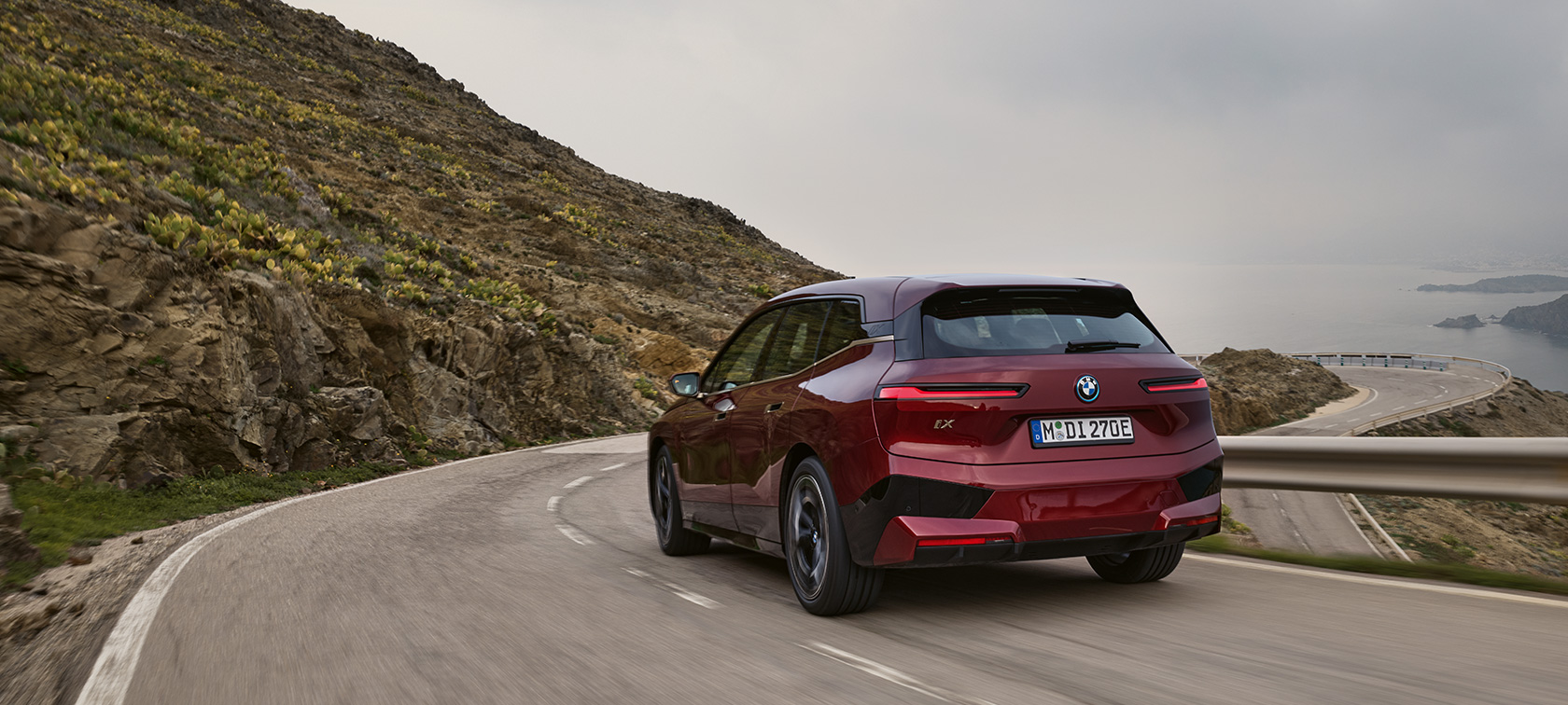 BMW iX, i20, 2021, ηλεκτρικό SUV, BMW iX, xDrive50, κινούμενη σε παραλιακό δρόμο BMW iX, i20, 2021, ηλεκτρικό SUV, BMW iX, xDrive50, κόκκινο Aventurin, πίσω λήψη, κινούμενη σε παραλιακό δρόμο