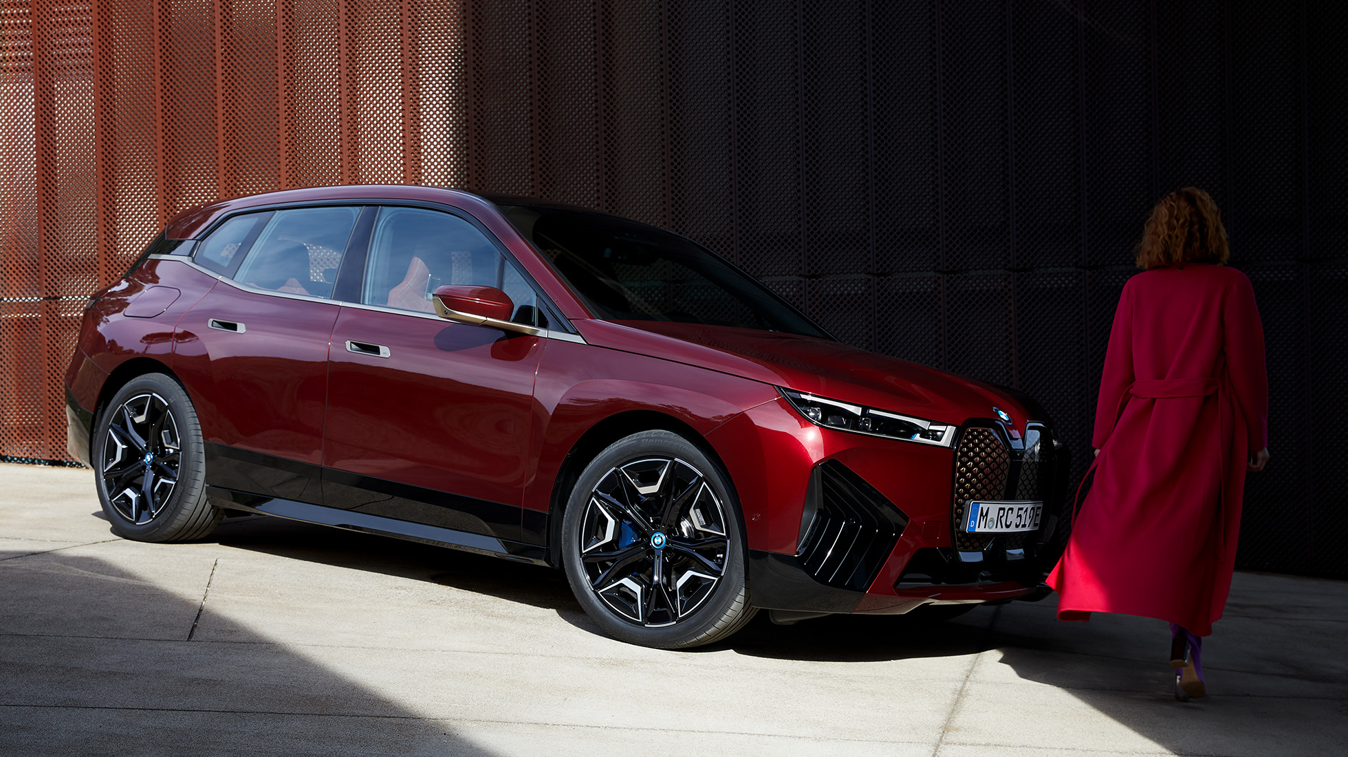 BMW iX πλαϊνή λήψη τρία τέταρτα στο εξωτερικό BMW iX Aventurin Red i20 πλαϊνή λήψη τρία τέταρτα στο εξωτερικό