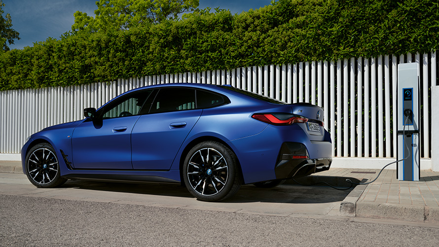 Πλαϊνή λήψη, BMW i4 eDrive40, G26, 2021, σε δημόσιο σταθμό ταχείας φόρτισης BMW i4 M50, G26, 2021, BMW Individual μπλε Frozen Portimao μεταλλικό, πλαϊνή λήψη σε δημόσιο σταθμό ταχείας φόρτισης