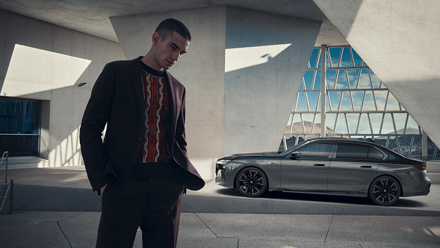 BMW Financial Services, BMW M760e xDrive Sedan, G70, πακέτο M Performance BMW Financial Services, BMW M760e xDrive Sedan, G70, πακέτο M Performance, χρώμα αμαξώματος BMW Individual μαύρο Sapphire σε διχρωμία, BMW Individual γκρι Dravite μεταλλικό, πλαϊνή λήψη, σταθμευμένη με άντρα στο προσκήνιο