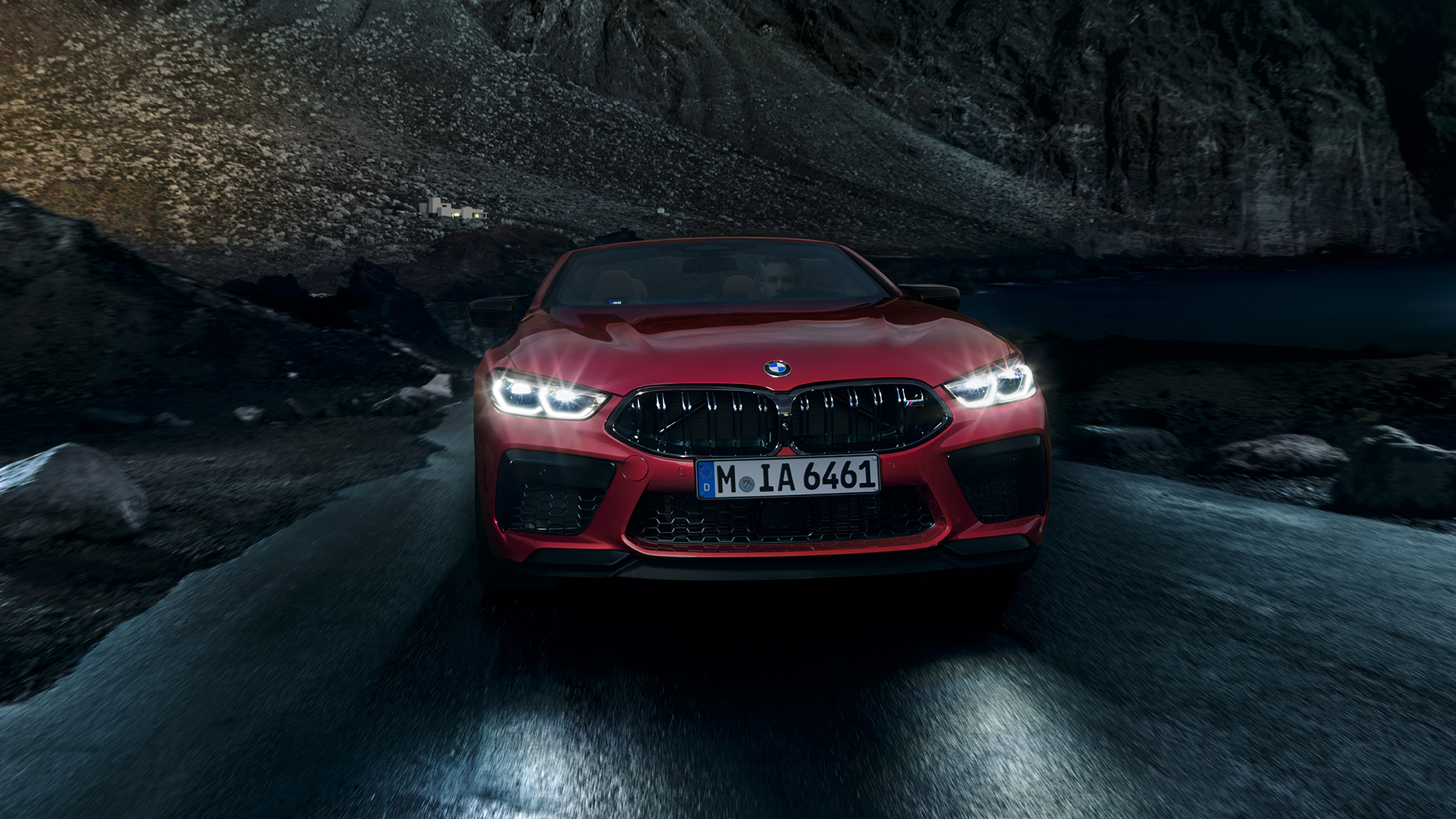 BMW M8 Competition Cabrio, μπροστινή λήψη. BMW Μ8 Competition Cabrio σε κόκκινο Motegi μεταλλικό με αναμμένους προβολείς, μπροστινή λήψη, κινούμενη τη νύχτα.