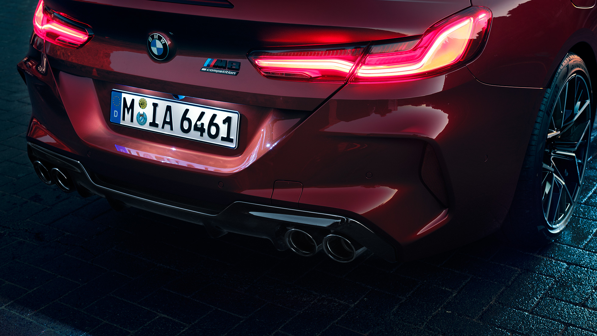 BMW M8 Competition Cabrio, κοντινή πίσω λήψη. BMW M8 Competition Cabrio σε κόκκινο Motegi μεταλλικό, κοντινή λήψη στο πίσω τμήμα με πίσω φώτα LED και σήμα M8 Competition.