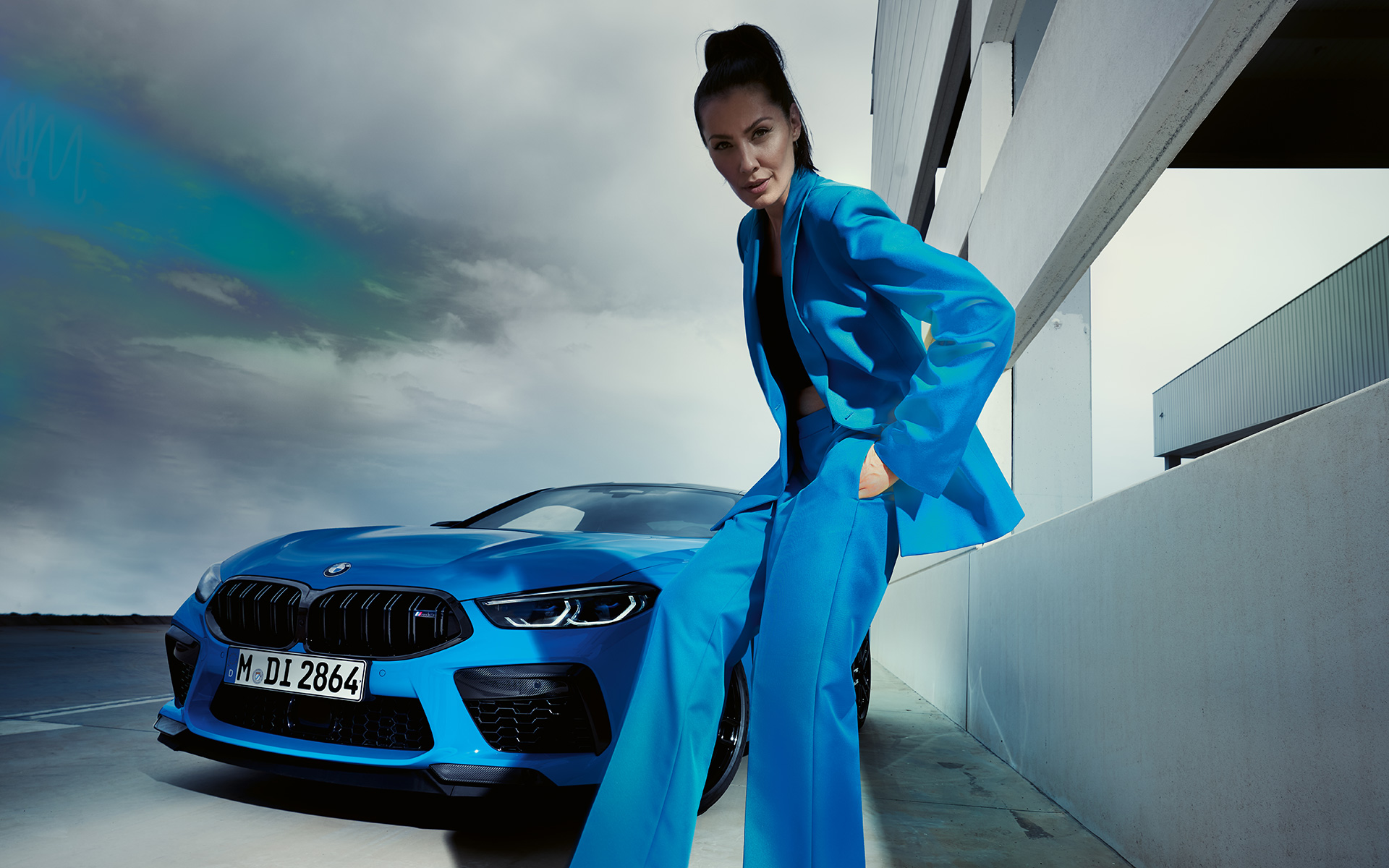 BMW M8 Competition Coupé, F92, LCI, 2022, μπροστινή λήψη τριών τετάρτων BMW M8 Competition Coupé, F92, LCI Facelift, 2022, μπλε Daytona Beach μη μεταλλικό, μπροστινή λήψη τριών τετάρτων με γυναικείο μοντέλο σε μπλε κοστούμι