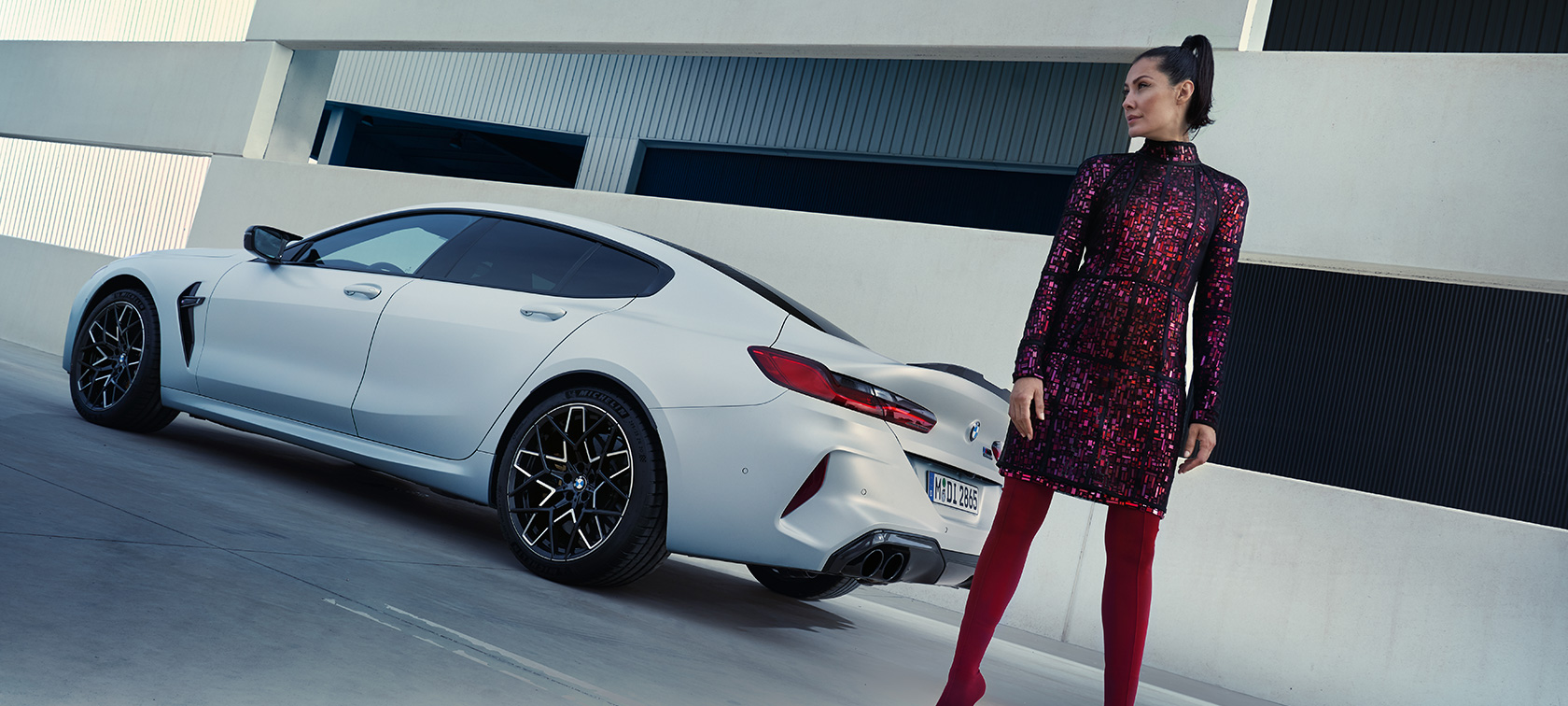 BMW M8 Competition Gran Coupé, F93, LCI, Facelift, 2022, BMW Individual λευκό Frozen Brilliant μεταλλικό, πίσω λήψη τριών τετάρτων, με γυναικείο μοντέλο δίπλα από το αυτοκίνητο