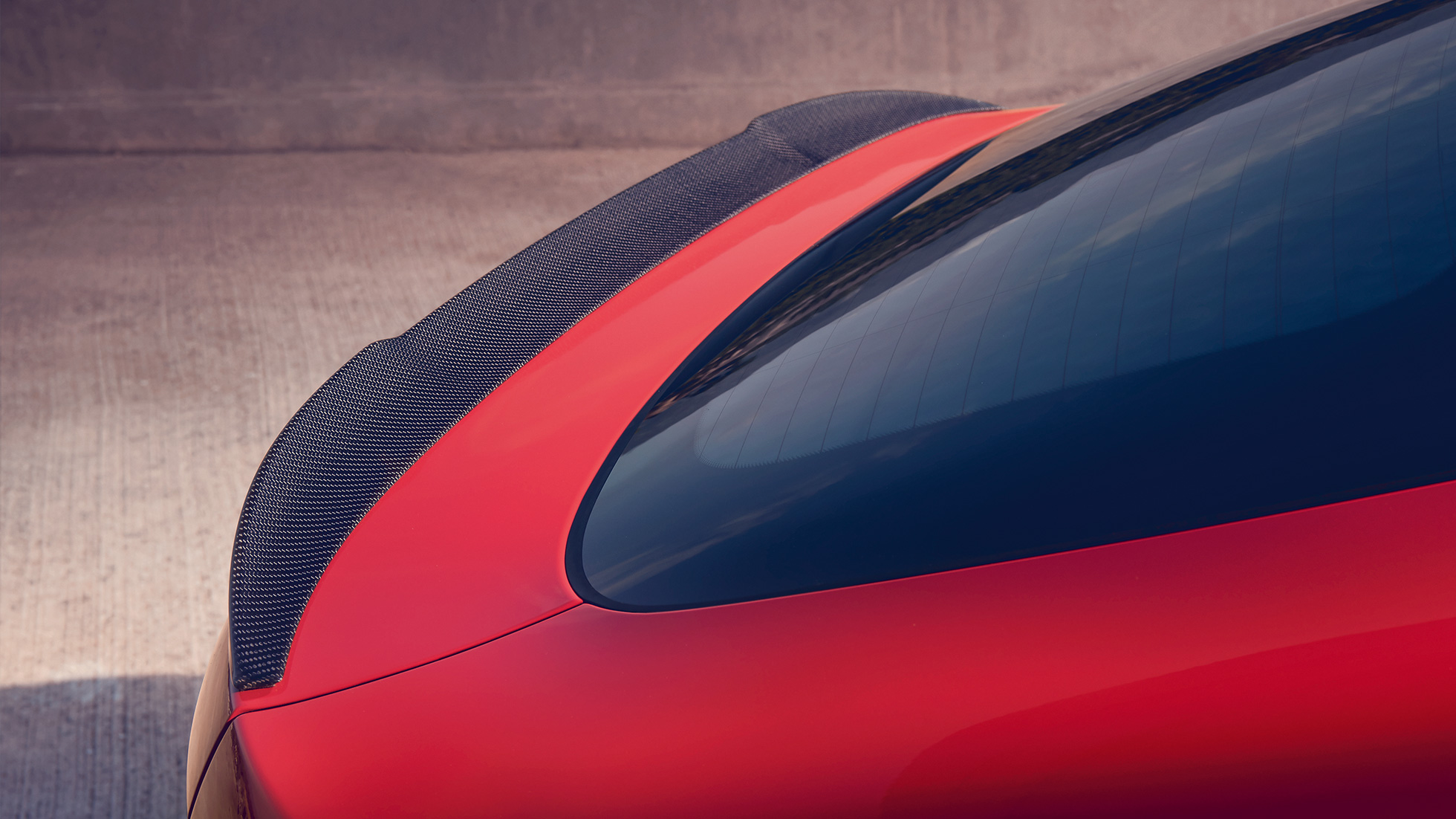 BMW X4 M Competition, πίσω αεροτομή Μ από ανθρακονήματα. BMW X4 M Competition σε κόκκινο Toronto μεταλλικό, εξωτερικό, πακέτο εξωτερικού εξοπλισμού M Carbon, λεπτομερής λήψη πίσω τμήματος με πίσω αεροτομή Μ από ανθρακονήματα.