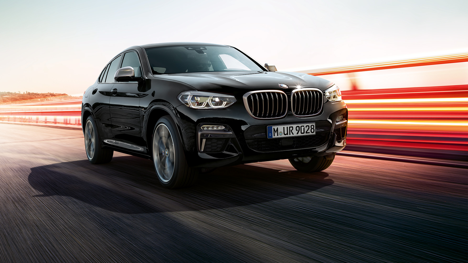BMW X4 M40i και BMW X4 M40d, μπροστινή λήψη τριών τετάρτων. BMW X4 M40i και BMW X4 M40d σε μαύρο Sapphire μεταλλικό, εξωτερικό, μπροστινή λήψη τριών τετάρτων, αριστερή πλευρά με φωτεινές γραμμές.