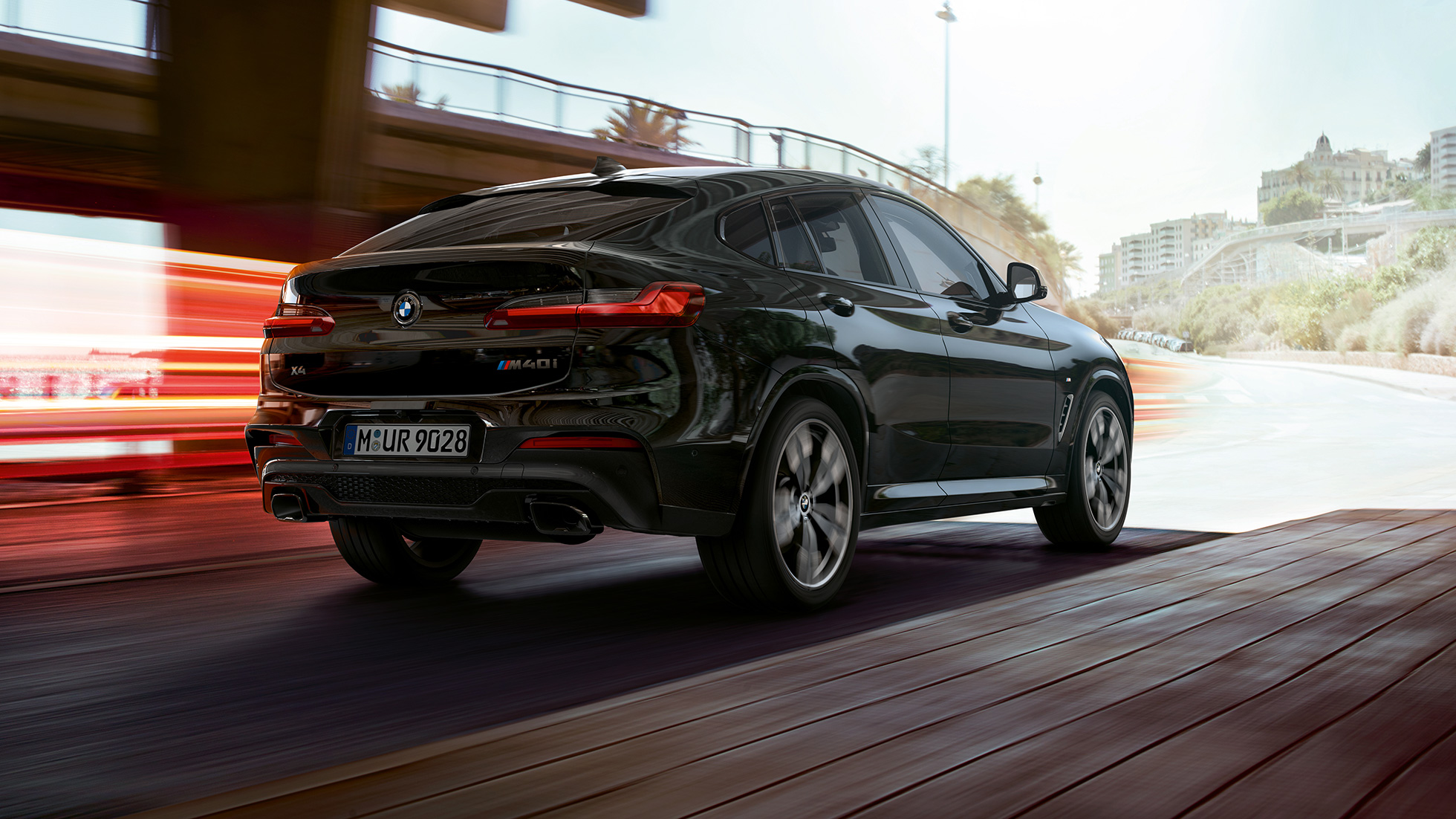 BMW X4 M40i, πίσω λήψη τριών τετάρτων. BMW X4 M40i σε μαύρο Sapphire μεταλλικό, εξωτερικό, πίσω λήψη τριών τετάρτων, δεξιά πλευρά με φωτεινές γραμμές.