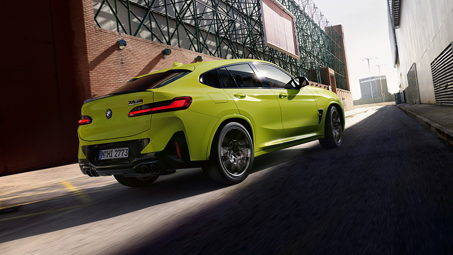 BMW X4 M Competition, F98, LCI, 2021, μπροστινή λήψη τριών τετάρτων BMW Χ4 Μ Competition, F98, LCI, Facelift, 2021, κίτρινο Sao Paulo, μπροστινή λήψη τριών τετάρτων, κινούμενη ανάμεσα σε βιομηχανικά κτίρια