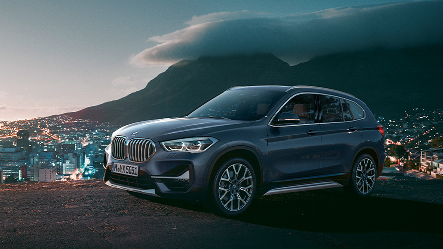 BMW X1, F48, δεύτερη γενιά, πλαϊνή λήψη τριών τετάρτων, σταθμευμένη μπροστά από σκηνικό πόλης BMW X, BMW X1, F48, δεύτερη γενιά, πλαϊνή λήψη τριών τετάρτων, σταθμευμένη μπροστά από σκηνικό πόλης