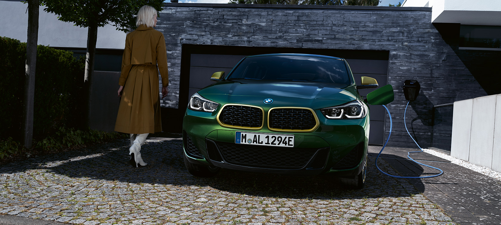 Μπροστινή λήψη, BMW X2 F39, πράσινο Sanremo μεταλλικό Μπροστινή λήψη κατά τη φόρτιση, με μοντέλο στην αριστερή πλευρά, BMW X2 F39, Sanremo Green μεταλλικό