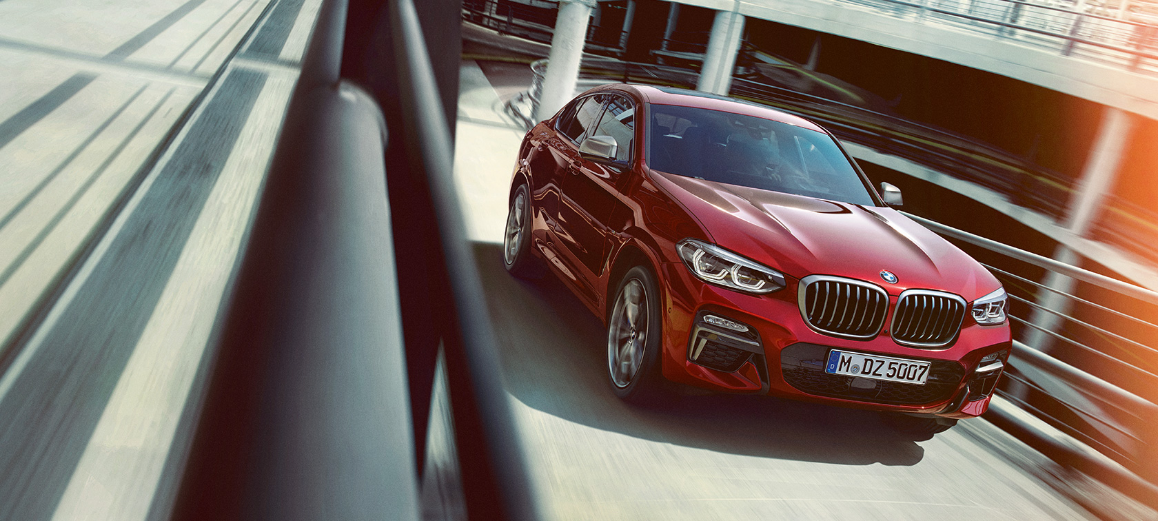 BMW X4, κινούμενη σε πολυώροφο σταθμό αυτοκινήτων BMW X4, G02 2018, κόκκινο Flamenco με εφέ Brilliant, πλαϊνή λήψη τριών τετάρτων, κινούμενη σε πολυώροφο σταθμό αυτοκινήτων