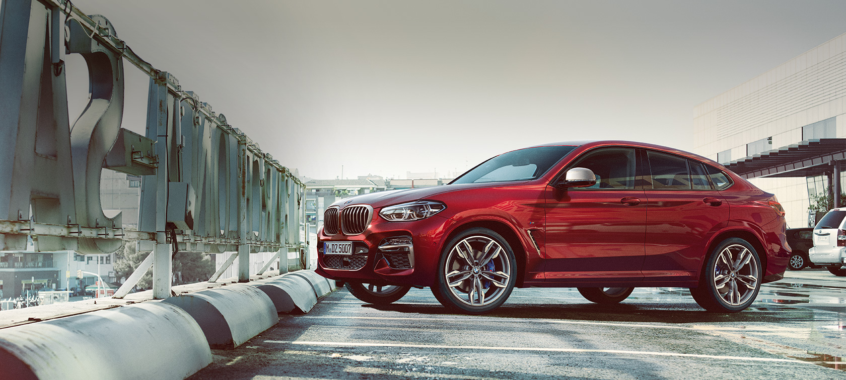 Πλαϊνή λήψη σταθμευμένης BMW X4 BMW X4 M40i, G02 2018, κόκκινο Flamenco με εφέ Brilliant, πλαϊνή λήψη, σταθμευμένη σε χώρο στάθμευσης