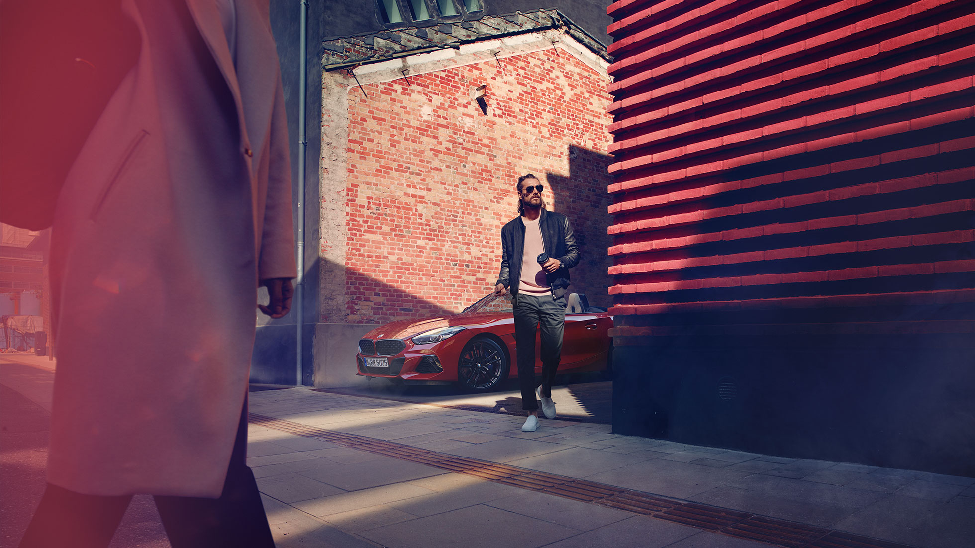BMW Z4 Roadster σε πλευρικό δρόμο Άντρας σε πλευρικό δρόμο, μπροστά από την BMW Z4 Roadster
