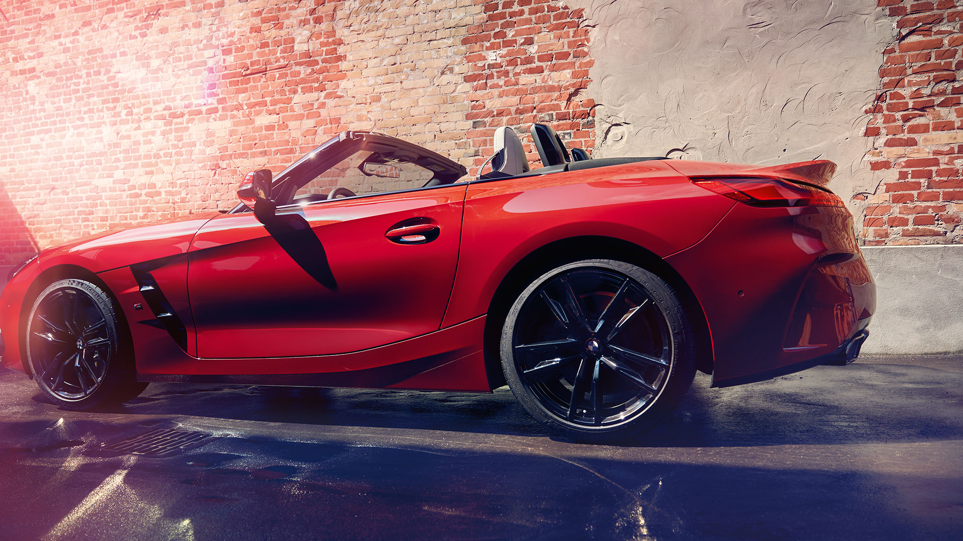 Πλαϊνή λήψη της BMW Z4 Roadster Πλαϊνή λήψη της BMW Z4 Roadster μπροστά από τοίχο με τούβλα