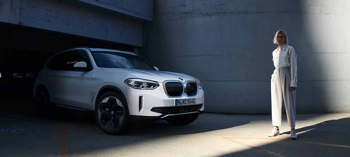 Γυναίκα μπροστά από το BMW iX3 BMW EfficientDynamics Γυναίκα μπροστά από το BMW iX3