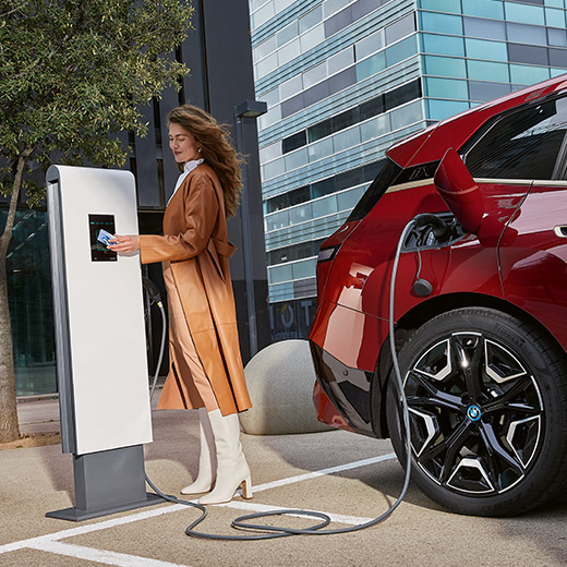 BMW iX i20, σε σταθμό φόρτισης, γυναίκα με κάρτα BMW Charging