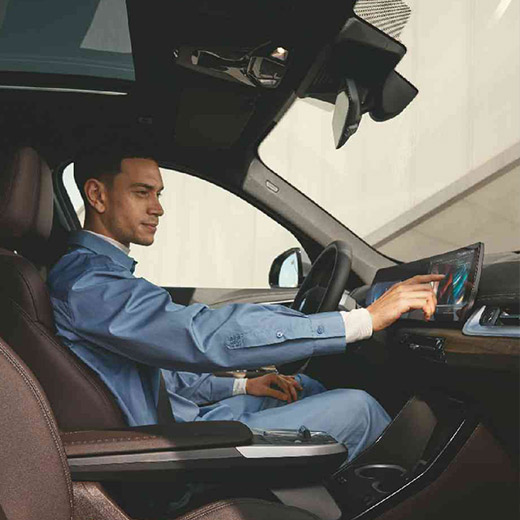 Connected Charging στο αυτοκίνητο, BMW, άντρας χειρίζεται την BMW Κυρτή Οθόνη