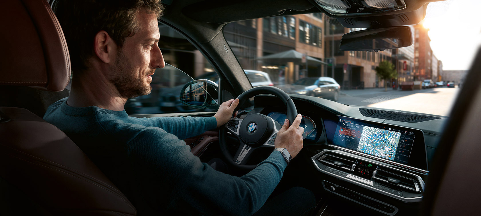 Πλοήγηση με Χάρτες BMW Άντρας οδηγεί μία BMW με το σύστημα πλοήγησης Χάρτες BMW στην Κεντρική Οθόνη Ελέγχου BMW