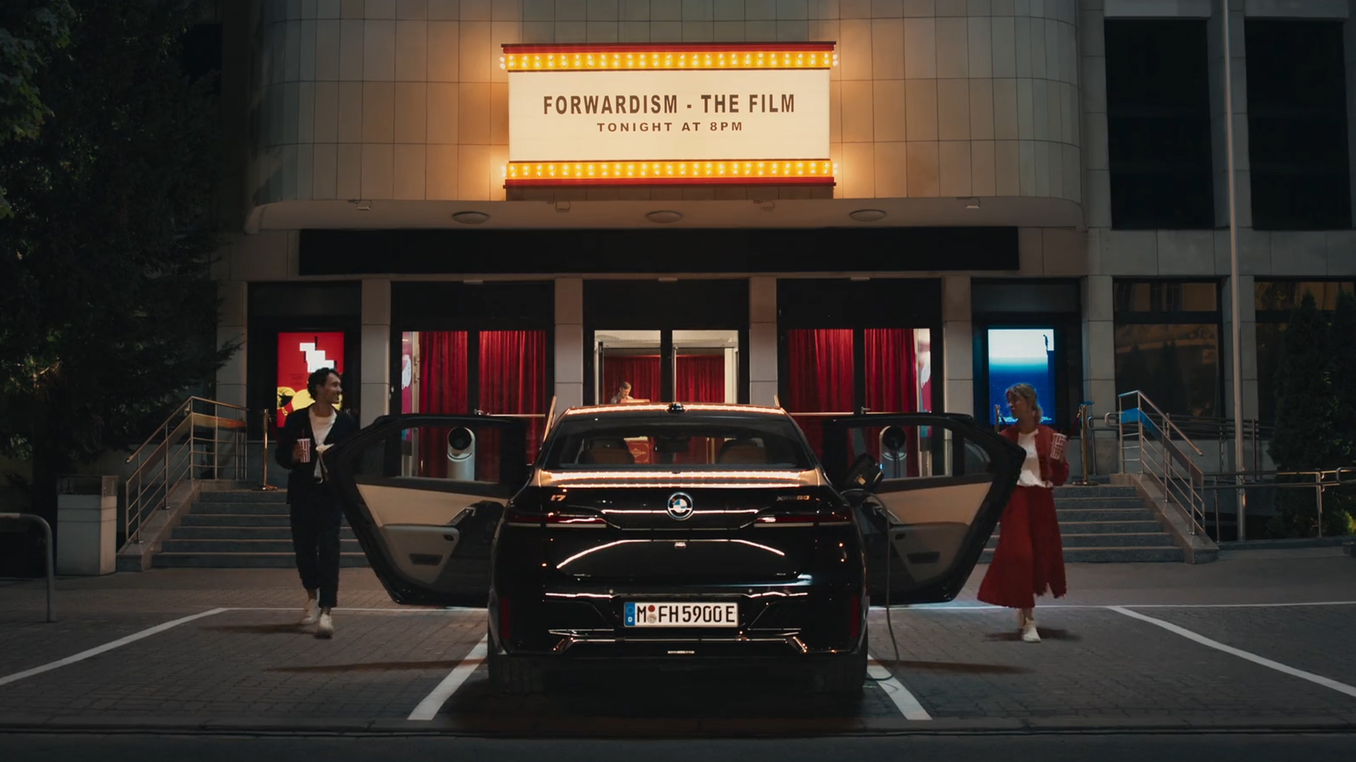 BMW iDrive, Challenge Cinema Experience BMW iDrive, Challenge Cinema Experience, G70, Πίσω λήψη μπροστά από έναν κινηματογράφο