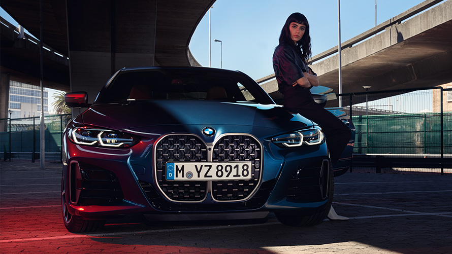 Γυναίκα στηρίζεται σε μία BMW Σειρά 4 Coupé Απομακρυσμένη Αναβάθμιση Λογισμικού, γυναίκα στηρίζεται σε μία BMW Σειρά 4 Coupé