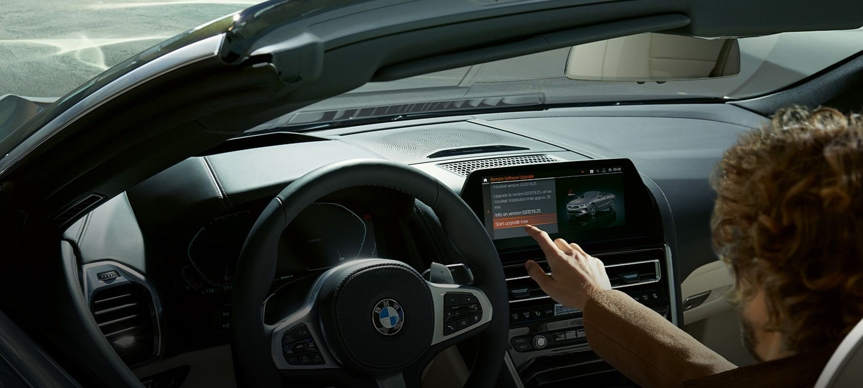 BMW Απομακρυσμένη Αναβάθμιση Λογισμικού Άντρας κάθεται μέσα σε μία BMW και ξεκινά την BMW Απομακρυσμένη Αναβάθμιση Λογισμικού