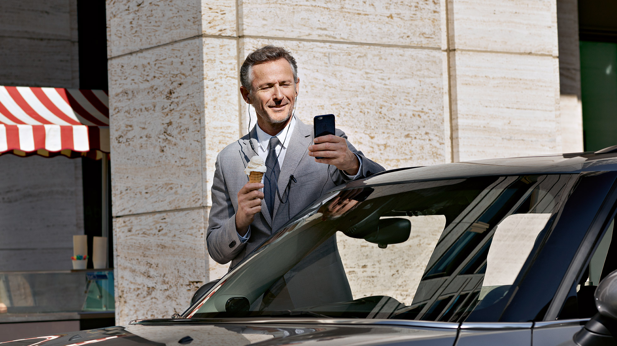 BMW Corporate After Sales, έλεγχος κόστους BMW Corporate After Sales: Άντρας τρώει παγωτό και ελέγχει τα οικονομικά του από ένα smartphone