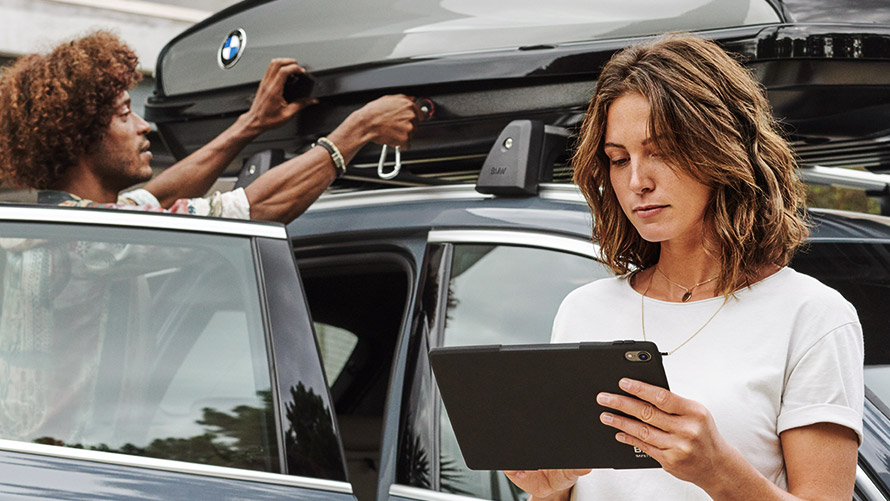 Γυναίκα με tablet μπροστά από μία BMW BMW Financial Services, γυναίκα με tablet μπροστά από μία BMW