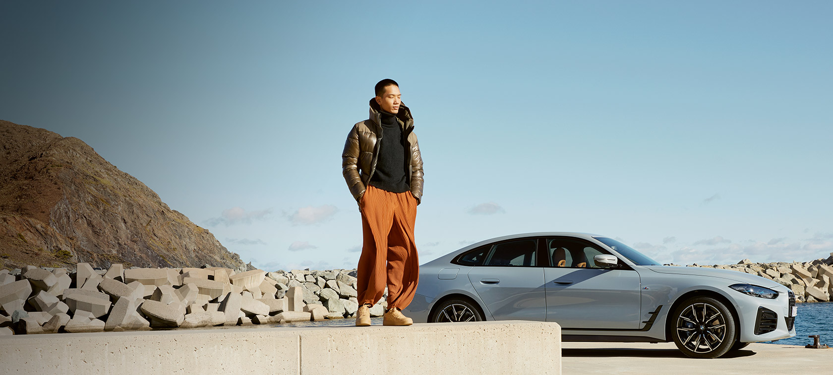 BMW Service Inclusive BMW Service Inclusive, άντρας μπροστά από την BMW i4 σε ακτή