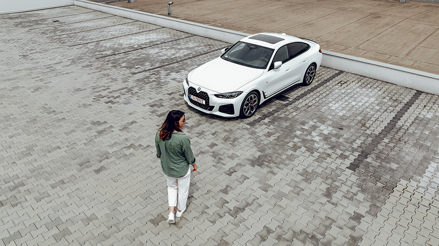 Γυναίκα περπατά προς την BMW i4 κοιτώντας προς τη δεξιά πλευρά. Γυναίκα περπατά προς την BMW i4 κοιτώντας προς τη δεξιά πλευρά.