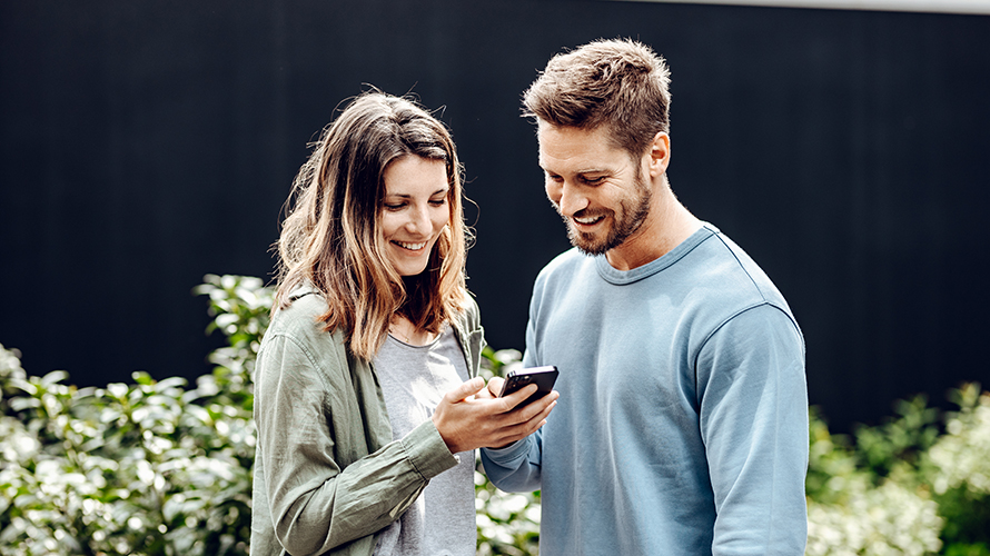 Ένας άντρας και μία γυναίκα κοιτούν στο smartphone της γυναίκας. Της δείχνει κάτι στην οθόνη. Ένας άντρας και μία γυναίκα κοιτούν στο smartphone της γυναίκας. Της δείχνει κάτι στην οθόνη.