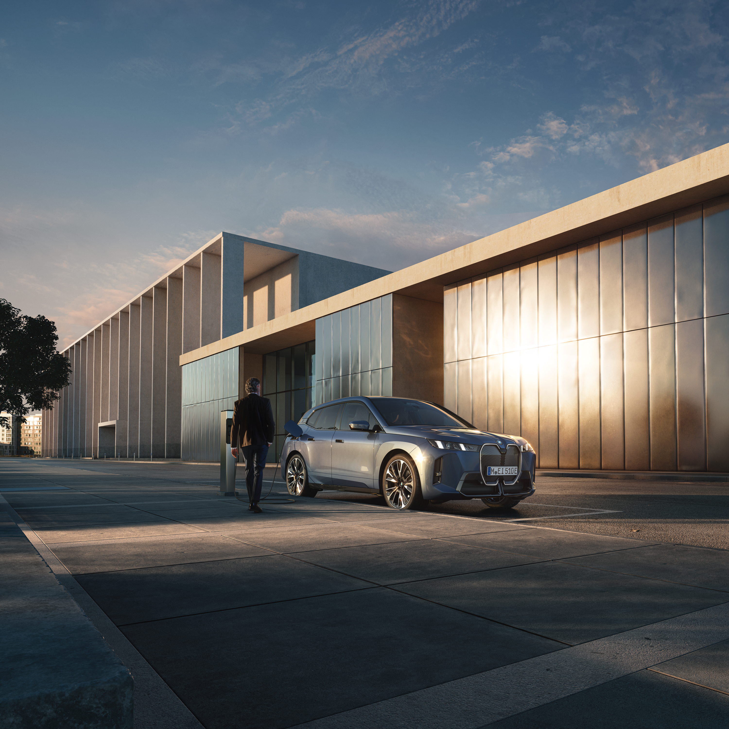 Ένας άνθρωπος περπατά προς μια BMW που φορτίζει