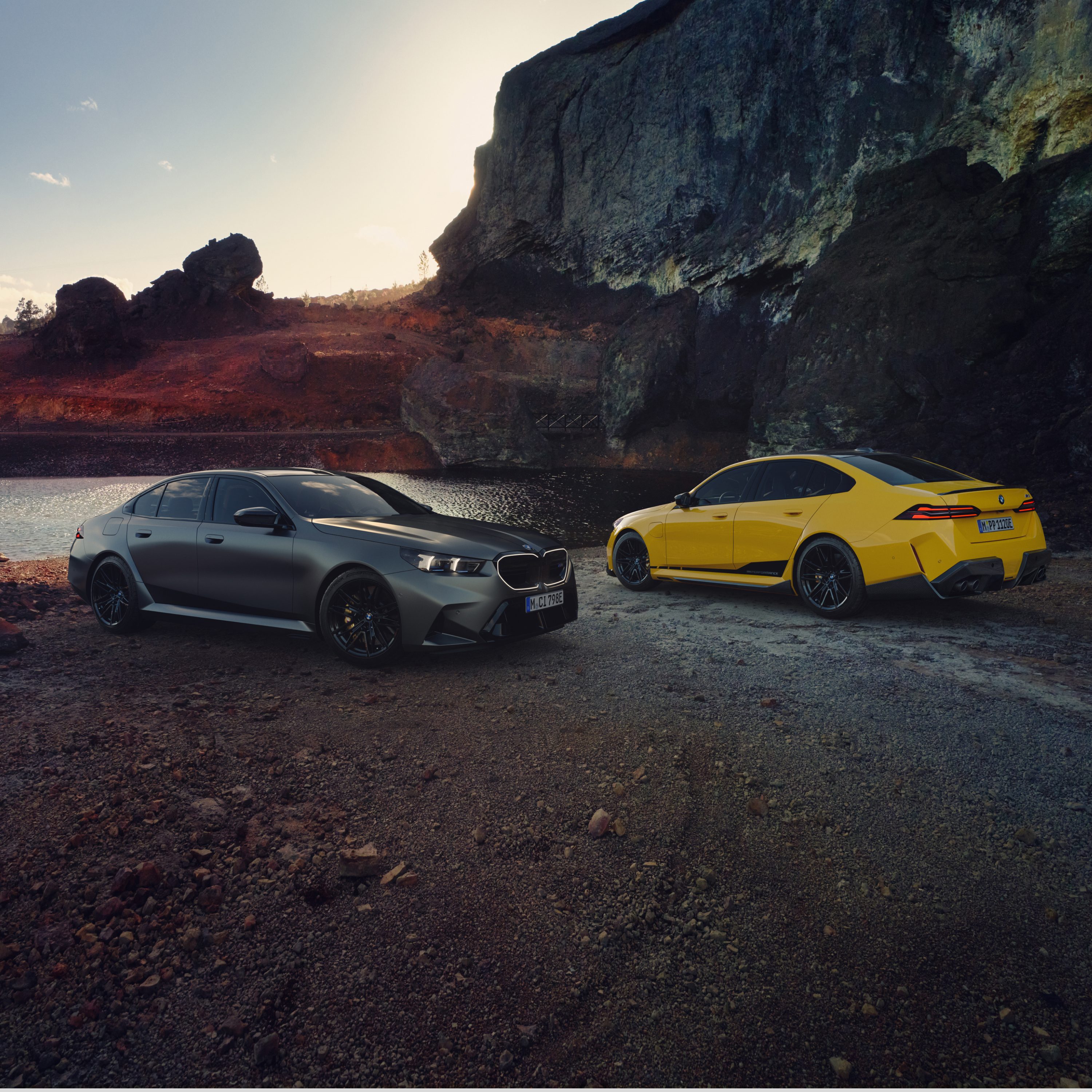 Δύο αυτοκίνητα της BMW Σειρά 5 είναι σταθμευμένα στην παραλία μπροστά από έναν βράχο