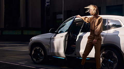 BMW Financial Services, γυναίκα μπροστά από την BMW iX3 BMW Financial Services, γυναίκα μπροστά από την BMW iX3