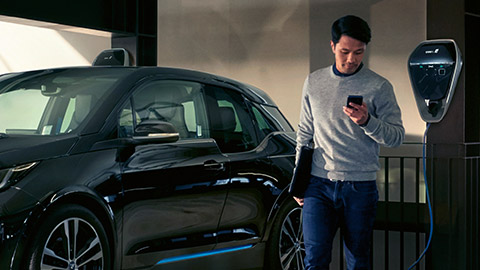 BMW Financial Services, άντρας με BMW i3 σε σταθμό φόρτισης BMW Financial Services, άντρας με BMW i3 σε σταθμό φόρτισης
